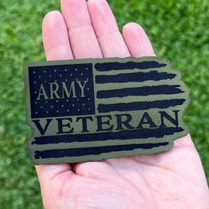 May include: Green and black fabric patch with a distressed American flag design and the text "ARMY VETERAN".