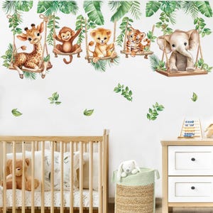 May include: A wall decal featuring five adorable jungle animals: a giraffe, monkey, lion cub, tiger cub, and elephant, each swinging from a wooden swing. Green leaves and vines surround the animals, creating a playful, jungle-themed nursery decor.