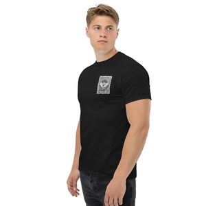 Op de afbeelding: Zwart T-shirt met een vintage postzegelgrafiek met een vliegtuig en de tekst "UNITED STATES OF AMERICA".