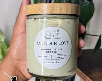 May include: A glass jar of "Lavender Love" whipped body butter with a wooden lid. The jar contains a light green cream and has a label with the brand name "Holistic Heaven". The jar is 250g.