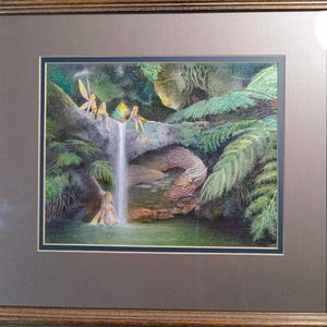 Op de afbeelding: Een aquarel schilderij van een magisch boslandschap met drie feeën en een draak. De feeën vliegen in de buurt van een waterval en de draak rust op een rots.