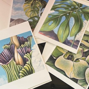 May include: Set of four blank greeting cards featuring botanical illustrations of tropical plants. The cards are white with a textured surface and have a blank inside for writing a message.