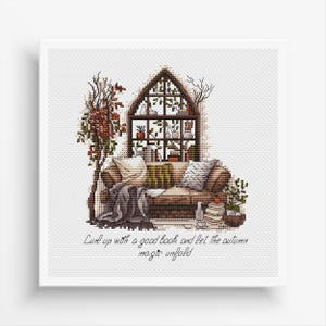 May include: A cross-stitch pattern featuring a cozy living room scene with a couch, a bookshelf, and plants. The text "Curl up with a good book and let the autumn magic unfold" is written below the image.