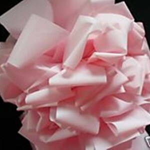 May include: A pile of soft, pink tissue paper, crumpled and gathered together. The paper is light and airy, with a delicate texture.