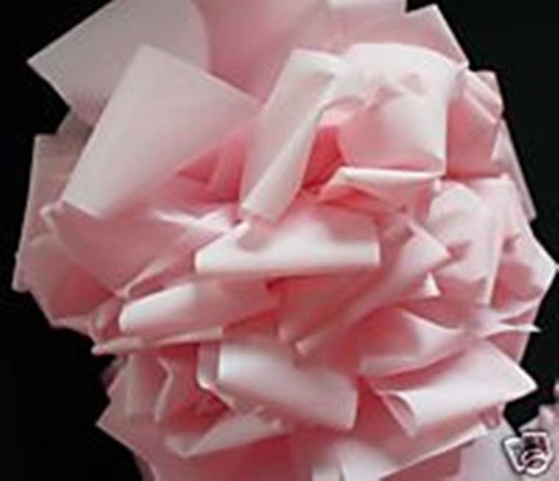 May include: A pile of soft, pink tissue paper, crumpled and gathered together. The paper is light and airy, with a delicate texture.