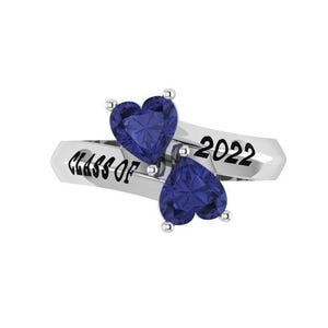 May include: A silver ring with two heart-shaped, dark blue gemstones. The ring is inscribed with "CLASS OF" and "2022" in a simple font. The gemstones are set on a diagonal, creating a unique design.