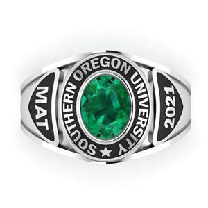 May include: A silver class ring featuring a central oval emerald-green gemstone. The ring is engraved with "SOUTHERN OREGON UNIVERSITY" and the year "2021". The sides display the letters "MAT".