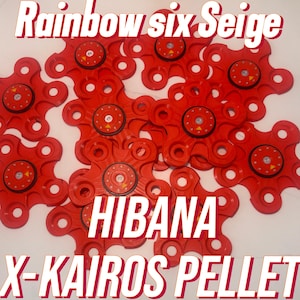 May include: A collection of red, star-shaped objects with circular centers and the text "Rainbow Six Siege," "Hibana," and "X-Kairos Pellet" in white. The objects have multiple holes and a central circular design.