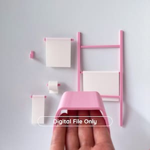 Può includere: Un set da bagno rosa, tra cui un portasciugamani a scala, un portarotolo di carta igienica e diversi portasciugamani. Il set è montato su una parete grigio chiaro. Il testo "Digital File Only" è visibile.