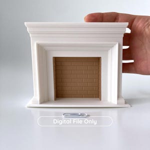 Puede incluir: Una chimenea blanca en miniatura con un interior de ladrillos marrones. La chimenea tiene un dise&ntilde;o cl&aacute;sico con molduras detalladas y una abertura rectangular. El texto "Digital File Only" se muestra en la parte inferior.