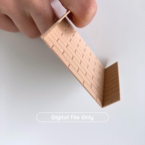 Puede incluir: Una peque&ntilde;a pared de ladrillos de papel doblada de color marr&oacute;n claro. El papel est&aacute; sujeto por los dedos de una persona. El texto "Digital File Only" est&aacute; impreso en la parte inferior de la imagen.