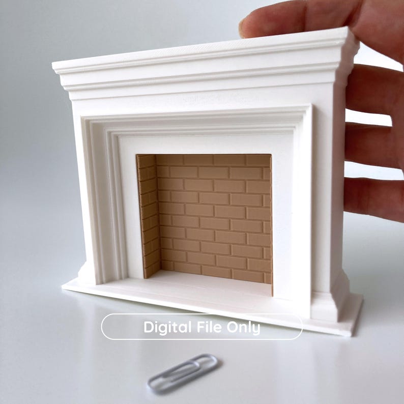 Puede incluir: Una repisa de chimenea blanca en miniatura con un interior de ladrillo marr&oacute;n. La repisa tiene un dise&ntilde;o cl&aacute;sico con molduras en capas y una abertura rectangular. El texto "Digital File Only" se muestra en la parte inferior. Un clip de papel est&aacute; en primer plano.