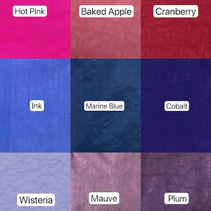 May include: Nine fabric swatches in various colors, each labeled with a color name. Colors include Hot Pink, Baked Apple, Cranberry, Ink, Marine Blue, Cobalt, Wisteria, Mauve, and Plum. The fabric appears to have a textured surface.
