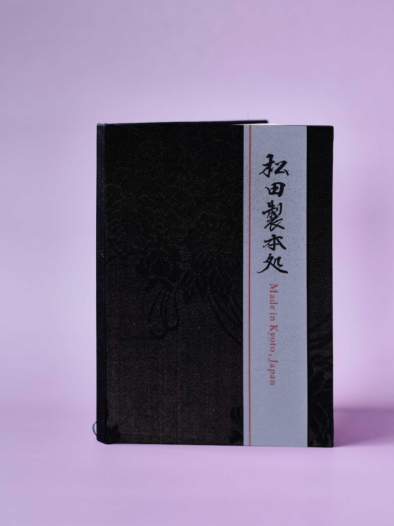 May include: A black notebook with a white label that says "Made in Kyoto, Japan" and Japanese text in red.