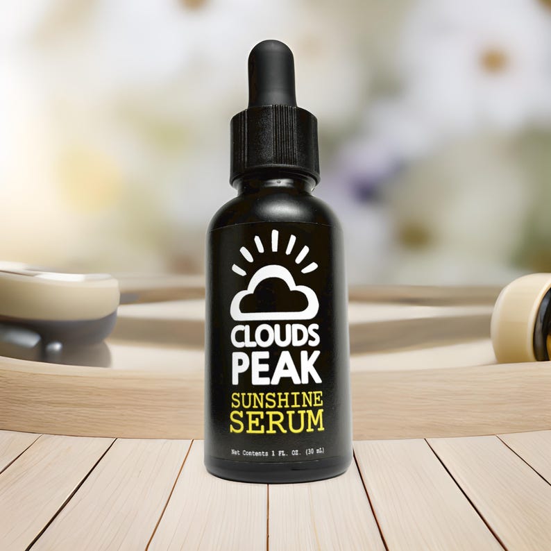 May include: A black glass bottle with a dropper top, labeled "Clouds Peak Sunshine Serum". The bottle is sitting on a wooden surface.