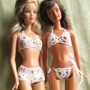 Op de afbeelding: Twee poppen die witte gebreide bikini-tops en -broekjes dragen. De bikini-tops hebben een halter-stijl en de broekjes zijn hoog getailleerd.
