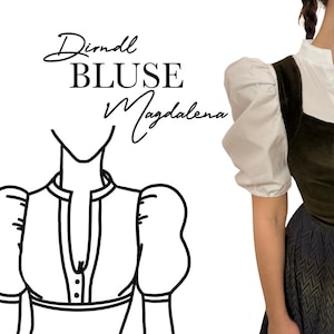 May include: A Dirndl Bluse Magdalena, a traditional German blouse, is shown. The blouse has white puffed sleeves and a dark green bodice. The text "Dirndl BLUSE Magdalena" is written in cursive. The blouse is part of a traditional German outfit.