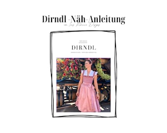 Può includere: Un dirndl rosa con rifiniture bianche e una camicetta bianca. Il dirndl è indossato da una donna in piedi davanti a un'arrangiamento floreale. Il testo "DIRNDL" è stampato sulla copertina di un libro.