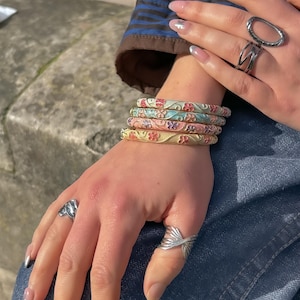 Op de afbeelding: Een witte keramische mok met een zwart handvat en de tekst "But First, Coffee" in een zwarte, vette letter. De mok staat op een wit oppervlak.