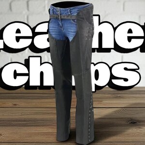 May include: Black leather chaps with a denim waistband and belt. The chaps have decorative rivets along the sides and the text "Leather Chaps" in large white letters.