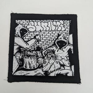 May include: Black and white patch featuring a graphic illustration. The design depicts figures in hooded cloaks and a police officer, with the word "SHRINK" in graffiti style. The patch has a black border.