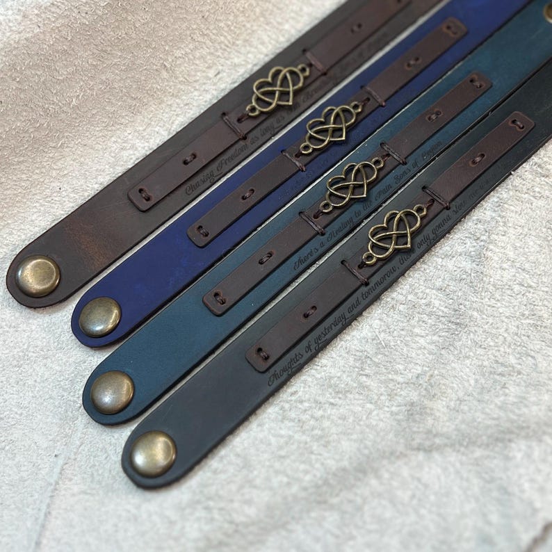 Puede incluir: Cuatro pulseras de cuero en tonos marr&oacute;n, azul, verde azulado y gris. Cada pulsera presenta un dije de coraz&oacute;n de metal y un cierre a presi&oacute;n. Las pulseras tienen texto grabado: "Chasing Freedom as way", "There's a healing to the main Stars of Heaven" y "Thoughts of yesterday and tomorrow, the only gonna".