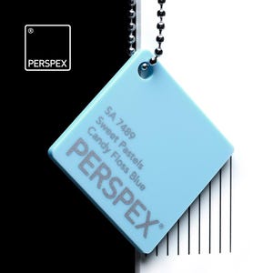 May include: A square, light blue Perspex color swatch, labeled "Candy Floss Blue" with the text "Sweet Pastels" and "SA 7489". The swatch is suspended by a silver ball chain against a black and white background.
