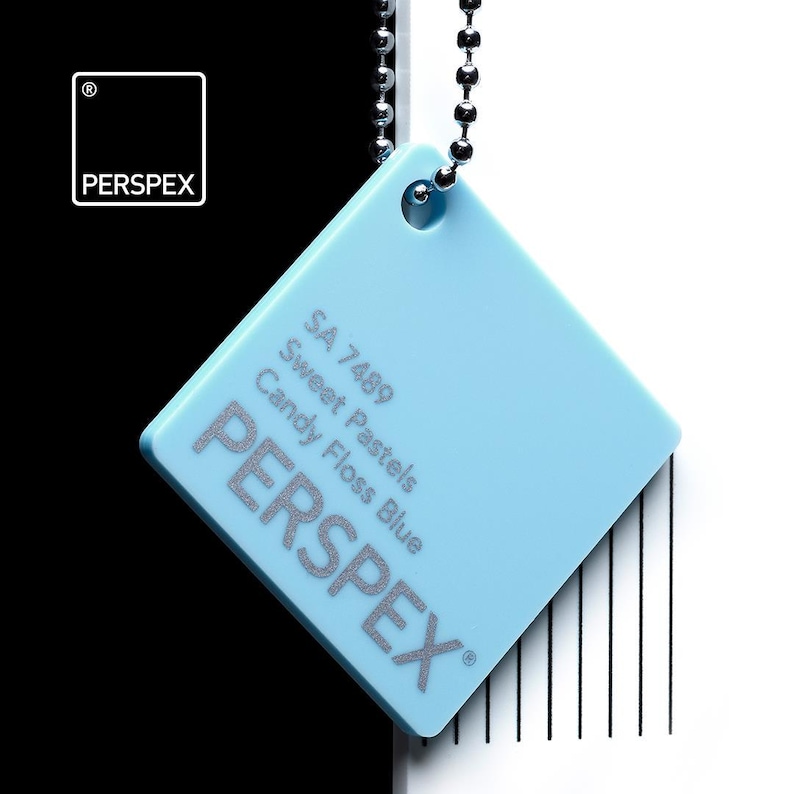 May include: A square, light blue Perspex color swatch, labeled "Candy Floss Blue" with the text "Sweet Pastels" and "SA 7489". The swatch is suspended by a silver ball chain against a black and white background.