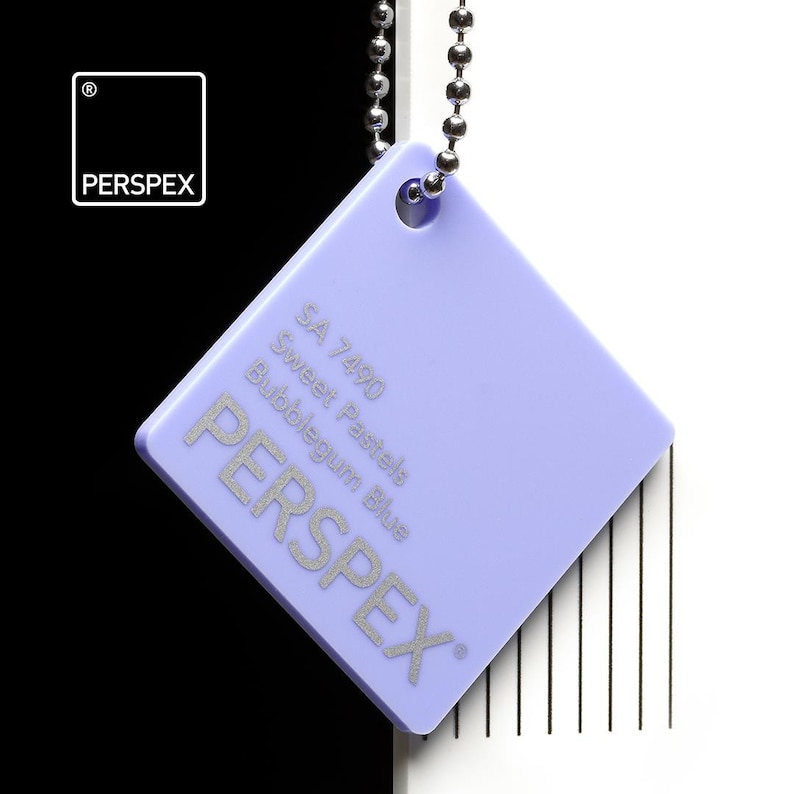 May include: A square, light purple Perspex color swatch with the text "SA 7490 Sweet Pastels Bubblegum Blue" and the brand name "PERSPEX" in silver. The swatch is attached to a silver ball chain.