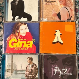 Może przedstawiać: Kolekcja sześciu płyt CD. Okładki album&oacute;w prezentują r&oacute;żnych artyst&oacute;w, w tym Ricky'ego Martina, Carrie Underwood i Chrisa Isaaka. Płyty CD reprezentują r&oacute;żne gatunki muzyczne, z wyraźnie widocznymi tytułami i nazwiskami artyst&oacute;w.
