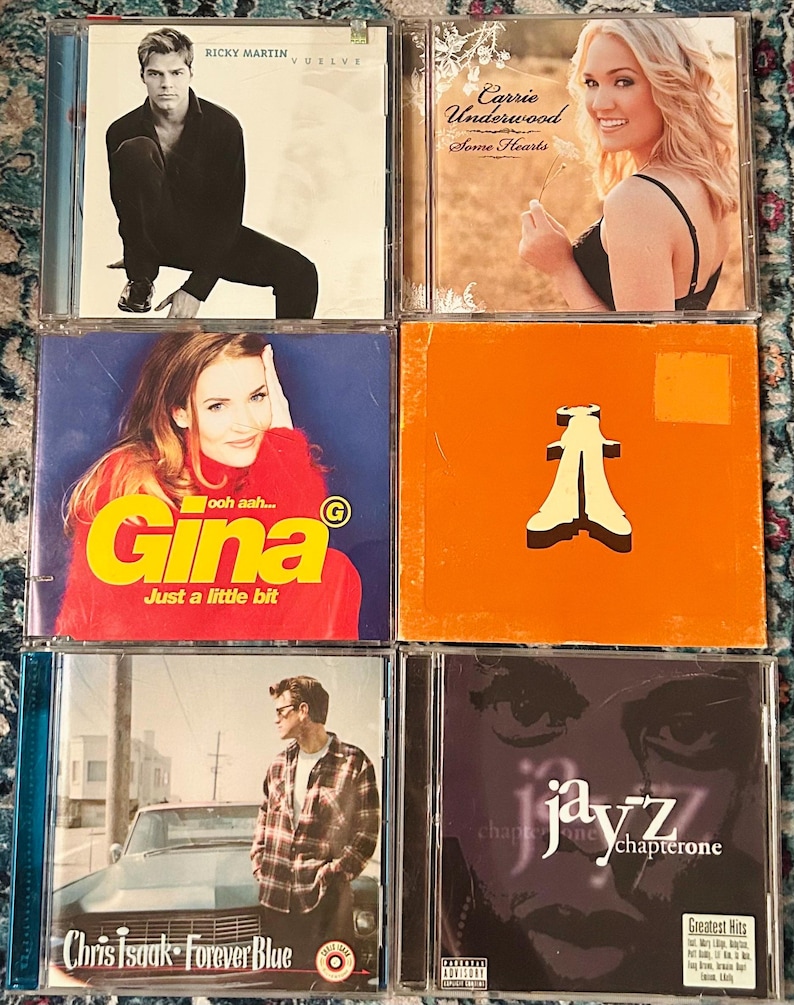 Może przedstawiać: Kolekcja sześciu płyt CD. Okładki album&oacute;w prezentują r&oacute;żnych artyst&oacute;w, w tym Ricky'ego Martina, Carrie Underwood i Chrisa Isaaka. Płyty CD reprezentują r&oacute;żne gatunki muzyczne, z wyraźnie widocznymi tytułami i nazwiskami artyst&oacute;w.