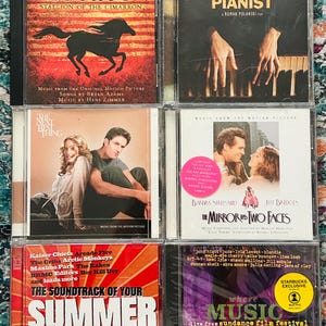 Könnte beinhalten: Sechs Musik-CDs, darunter Soundtracks und Alben. Zu sehen sind "Spirit: Stallion of the Cimarron", "The Pianist", "The Best Thing", "The Mirror Has Two Faces", "The Soundtrack of Your Summer" und eine Sundance-Compilation.