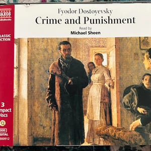 May include: A boxed audiobook of "Crime and Punishment" by Fyodor Dostoevsky, read by Michael Sheen. The cover shows a painting of a room with several people. The box is red and white with the Naxos Audiobooks logo and "Classic Fiction" text.