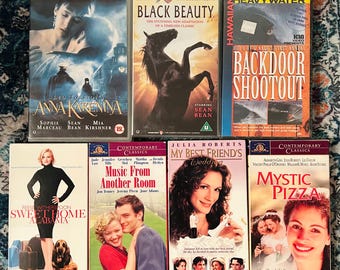 May include: A collection of VHS tapes featuring movie titles like "Anna Karenina," "Black Beauty," and "Sweet Home Alabama." The tapes have colorful covers with images of actors and movie scenes. The collection includes titles from various genres.