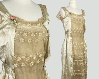 May include: A vintage ivory satin and lace dress with a delicate floral pattern. The dress has a fitted bodice and a flowing skirt. The dress is in excellent condition and would be perfect for a special occasion.