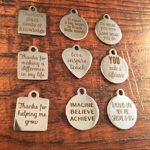 May include: A set of ten silver charm pendants with inspirational messages for teachers. The charms are engraved with phrases such as "Teachers plant seeds of knowledge", "Love, inspire, teach", and "You make a difference".