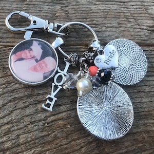May include: A silver keychain with a photo charm, a charm that says "LOVE", a heart charm that says "Bride", and other decorative charms.