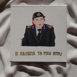 Könnte beinhalten: Ein Gemälde einer Frau in einer schwarzen Uniform mit goldenen Akzenten und einem schwarzen Hut. Die Frau hat rote Haare und schaut den Betrachter mit einem überraschten Ausdruck an. Der Text "Η ΠΑΝΑΓΙΑ ΤΟ ΡΙΞΕ ΑΥΤΟΣ" ist in Gelb unter der Frau geschrieben.