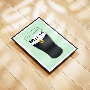 May include: A framed print with a green background and a black and white illustration of a pint glass with the text "Split the G" on the foam.