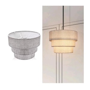 Pode incluir: Uma luminária pendente de tambor de três níveis com uma cúpula de tecido cinza texturizado. O design consiste em três camadas cilíndricas empilhadas de larguras variadas, suspensas por uma haste preta fina, emitindo um brilho quente.