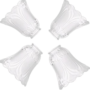Puede incluir: Un juego de cuatro pantallas de lámpara de cristal transparente, cada una con una silueta en forma de campana, acabado esmerilado y líneas verticales en relieve. Las pantallas tienen un borde festoneado y un patrón texturizado de hojas.