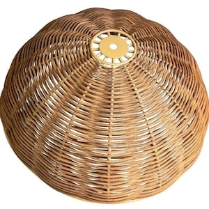 May include: A dome-shaped lampshade crafted from woven brown wicker material. The structure features a circular light-colored metal fitting at the center top with a small hole for mounting, showcasing a consistent radial pattern of reeds.
