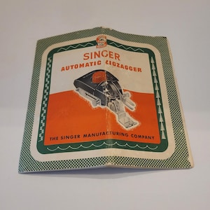 May include: Vintage Singer Automatic Zigzagger manual. The cover features a green and white border with the Singer logo at the top. The text "SINGER AUTOMATIC ZIGZAGGER" is displayed above an illustration of the machine. The background is orange.