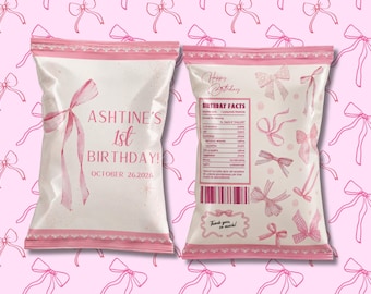 May include: Two white snack bags with pink trim and bow graphics. The front reads ASHTINE'S 1st BIRTHDAY! OCTOBER 26, 2026. The back features a BIRTHDAY FACTS nutrition label, a barcode, and the text Thank you so much! against a pink bow background.