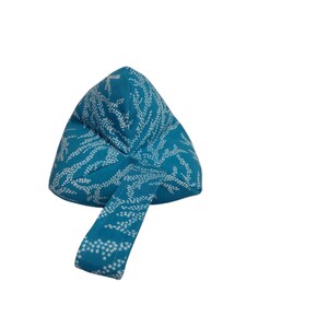 May include: A teal blue meditation cushion with a white floral pattern. The cushion has a handle for easy carrying.