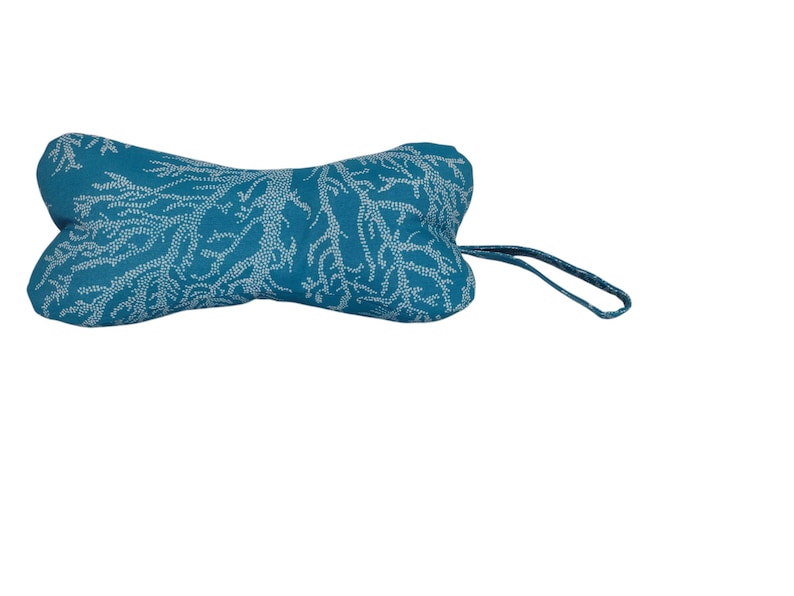 May include: Teal blue dog toy shaped like a bone with a white coral pattern and a white string attached.