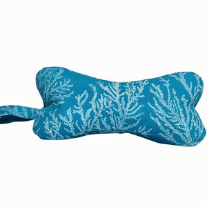 May include: A turquoise blue dog toy shaped like a bone with a white coral pattern.