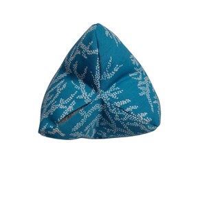 May include: A turquoise blue triangular cushion with a white coral reef pattern.