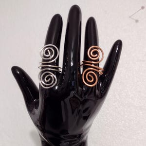 May include: A white ceramic mug with a black handle and the text "But First, Coffee" in a bold, black font. The mug is set against a blurred background, highlighting its clean design.