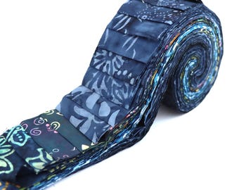 Pode incluir: Um rolo de tiras de tecido em vários tons de azul, com padrões florais e abstratos. O tecido está disposto em espiral, mostrando os diferentes desenhos e cores. As tiras têm cerca de 6,35 cm de largura, adequadas para quilting ou artesanato.
